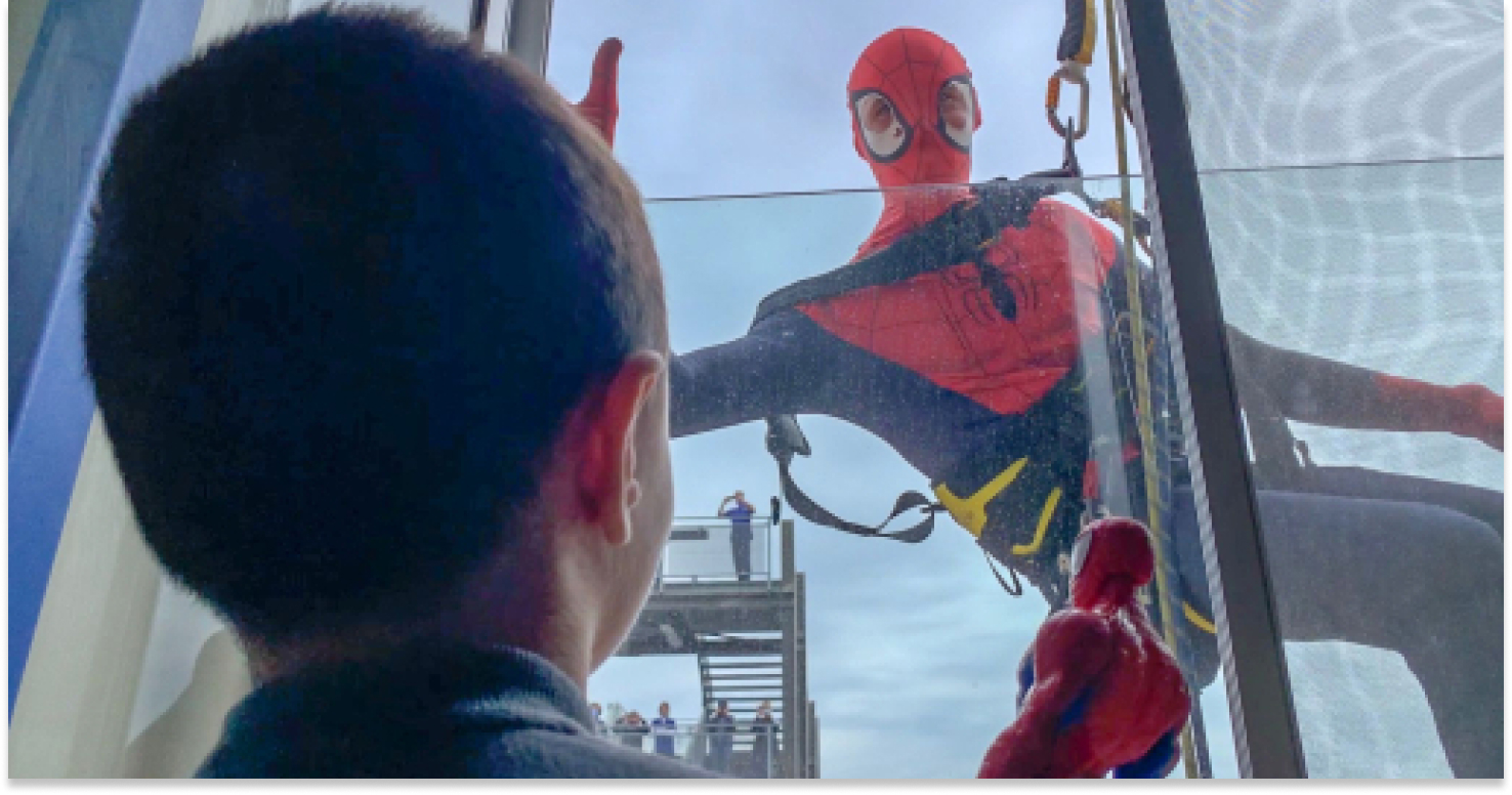 Spiderman alla finestra di un piccolo paziente con il pupazzo di Spiderman in mano